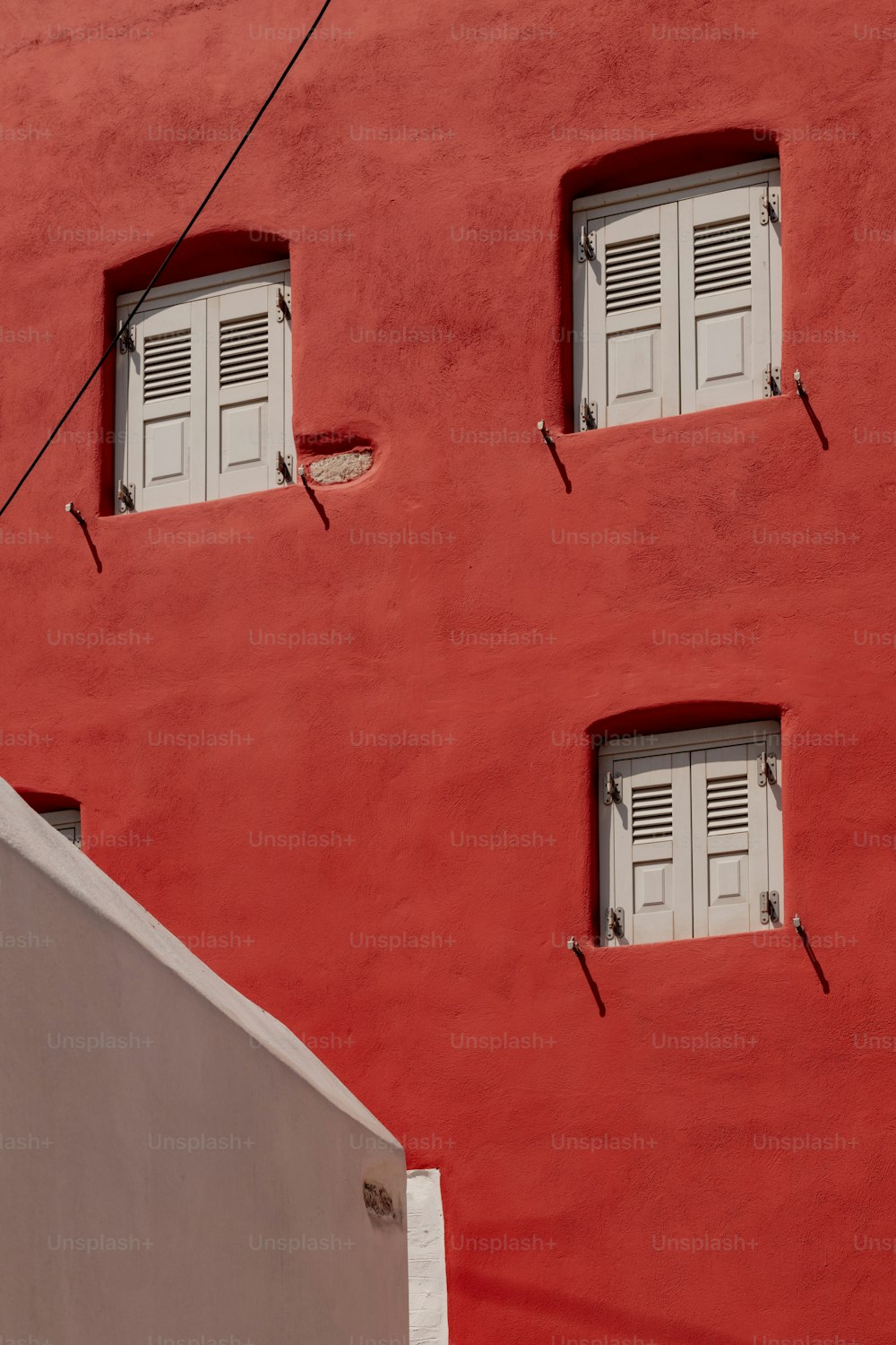 a red building with white shutters and windows