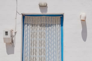 a window with a curtain hanging off of it's side