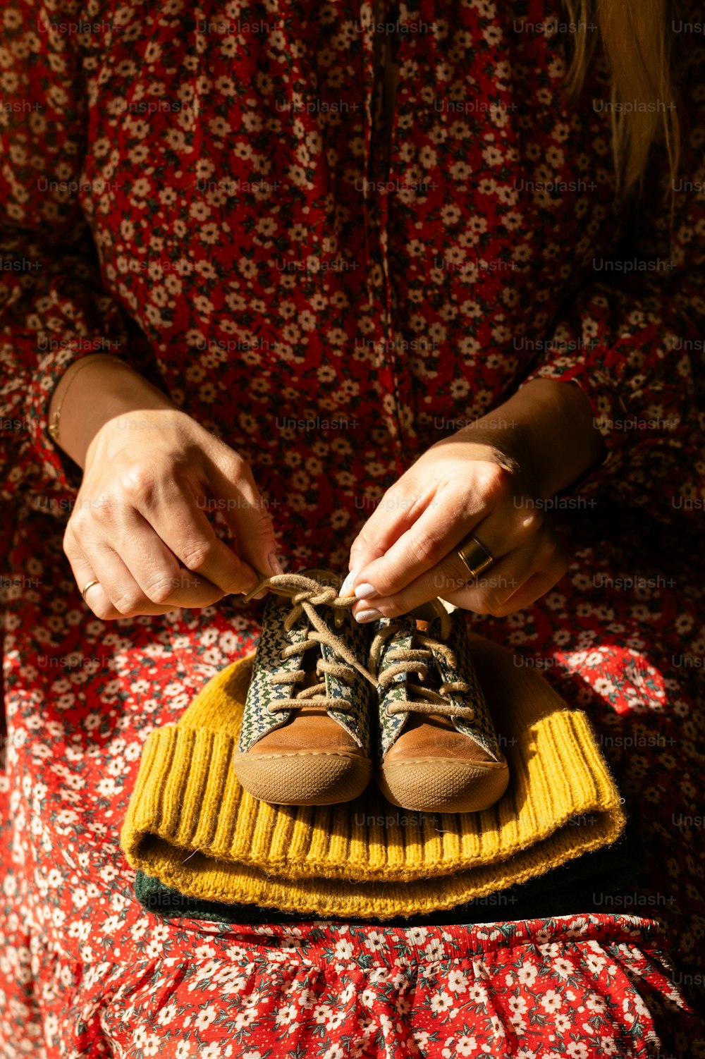 uma mulher amarrando um par de sapatos em cima de um cobertor