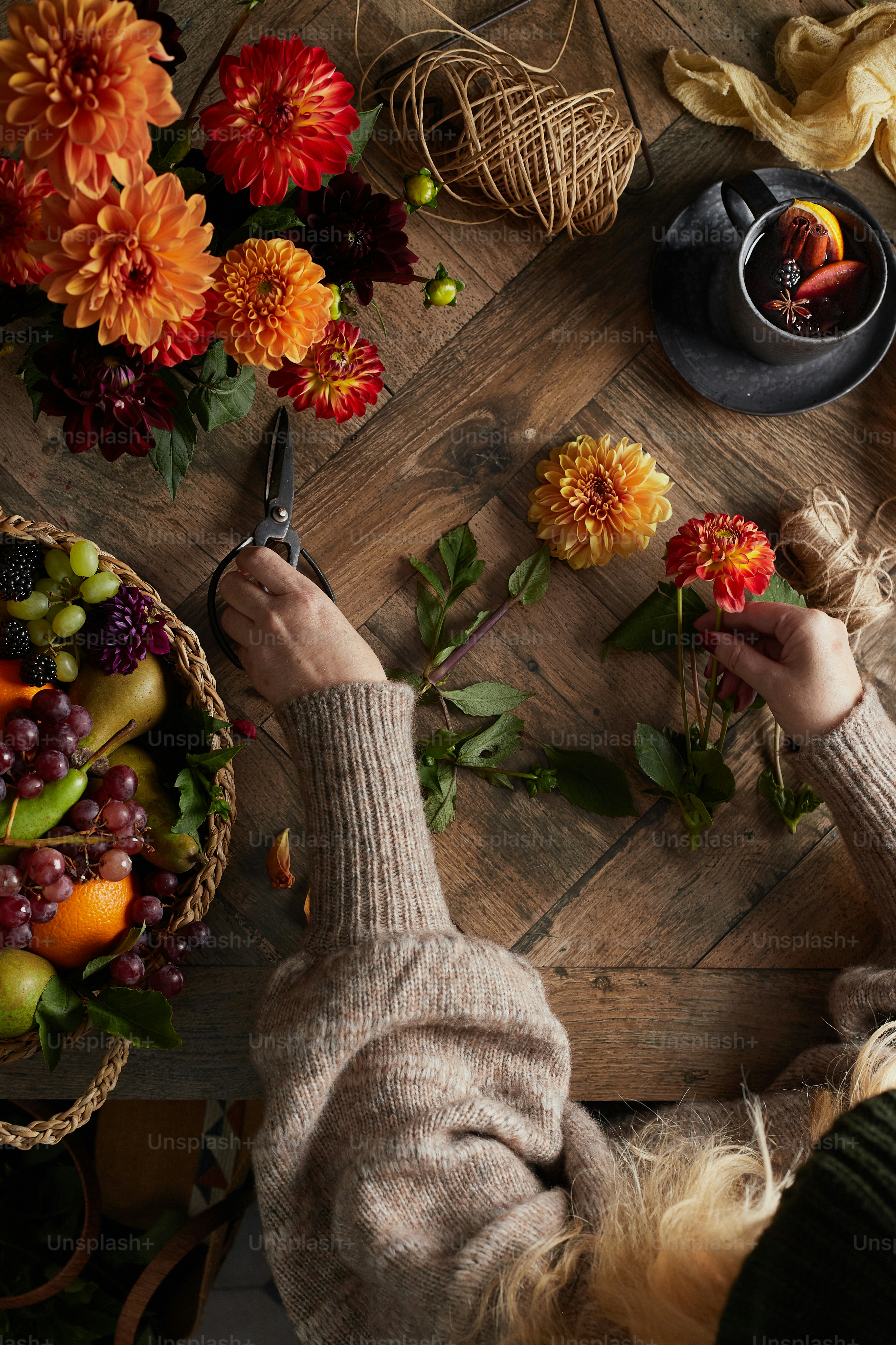 a person cutting flowers on a wooden table
