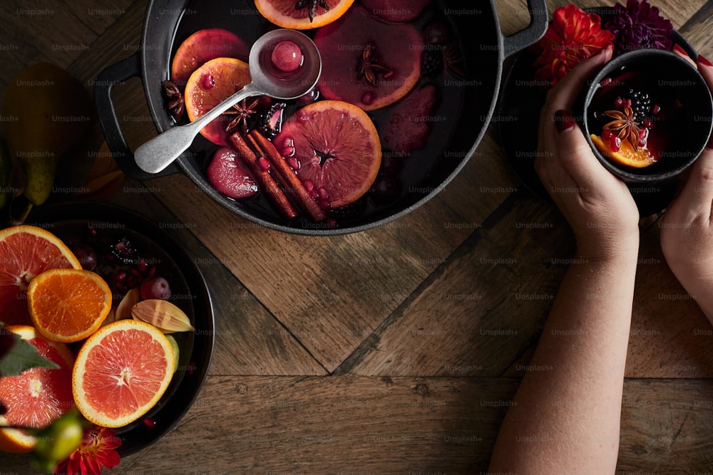 a person holding a bowl of blood oranges