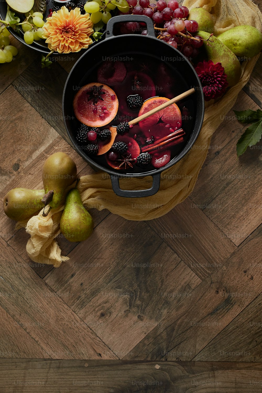 a wooden table topped with a pot filled with fruit