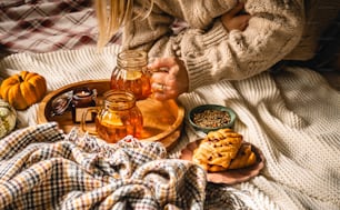 a woman sitting on a bed holding a jar of honey