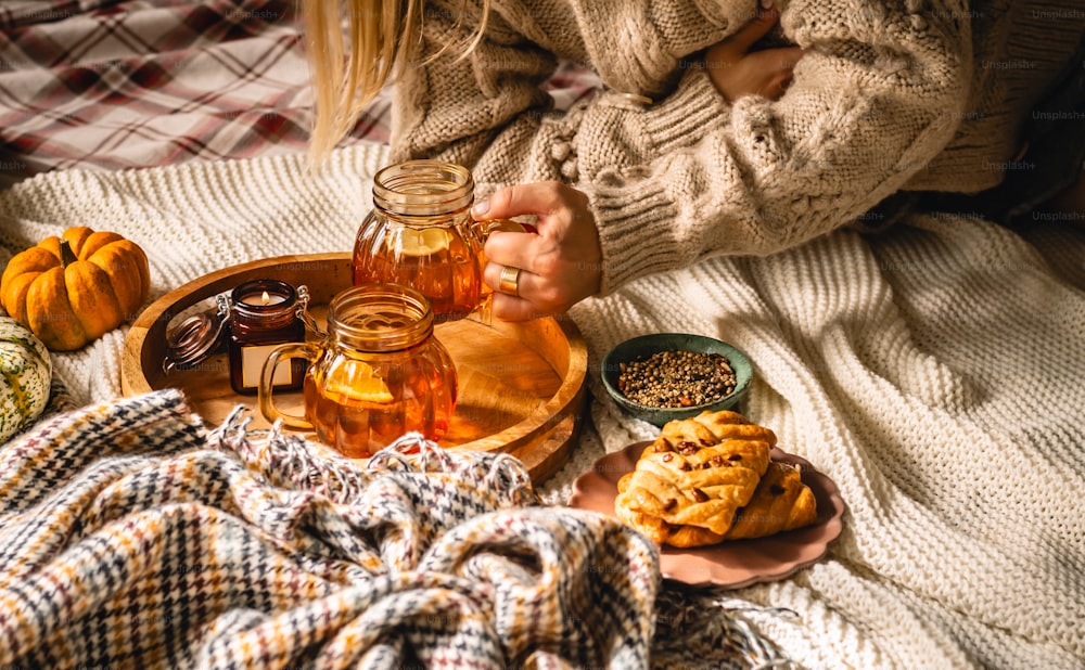 a woman sitting on a bed holding a jar of honey