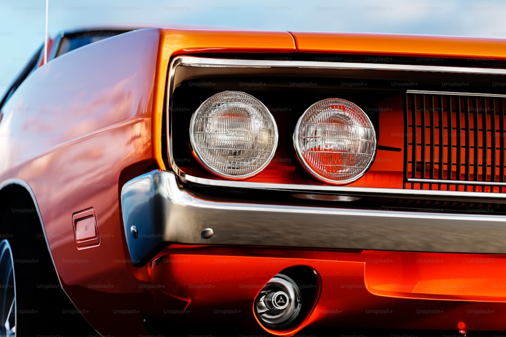 a close up of the front of an orange muscle car
