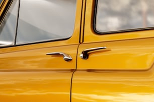 a close up of a door handle on a yellow car