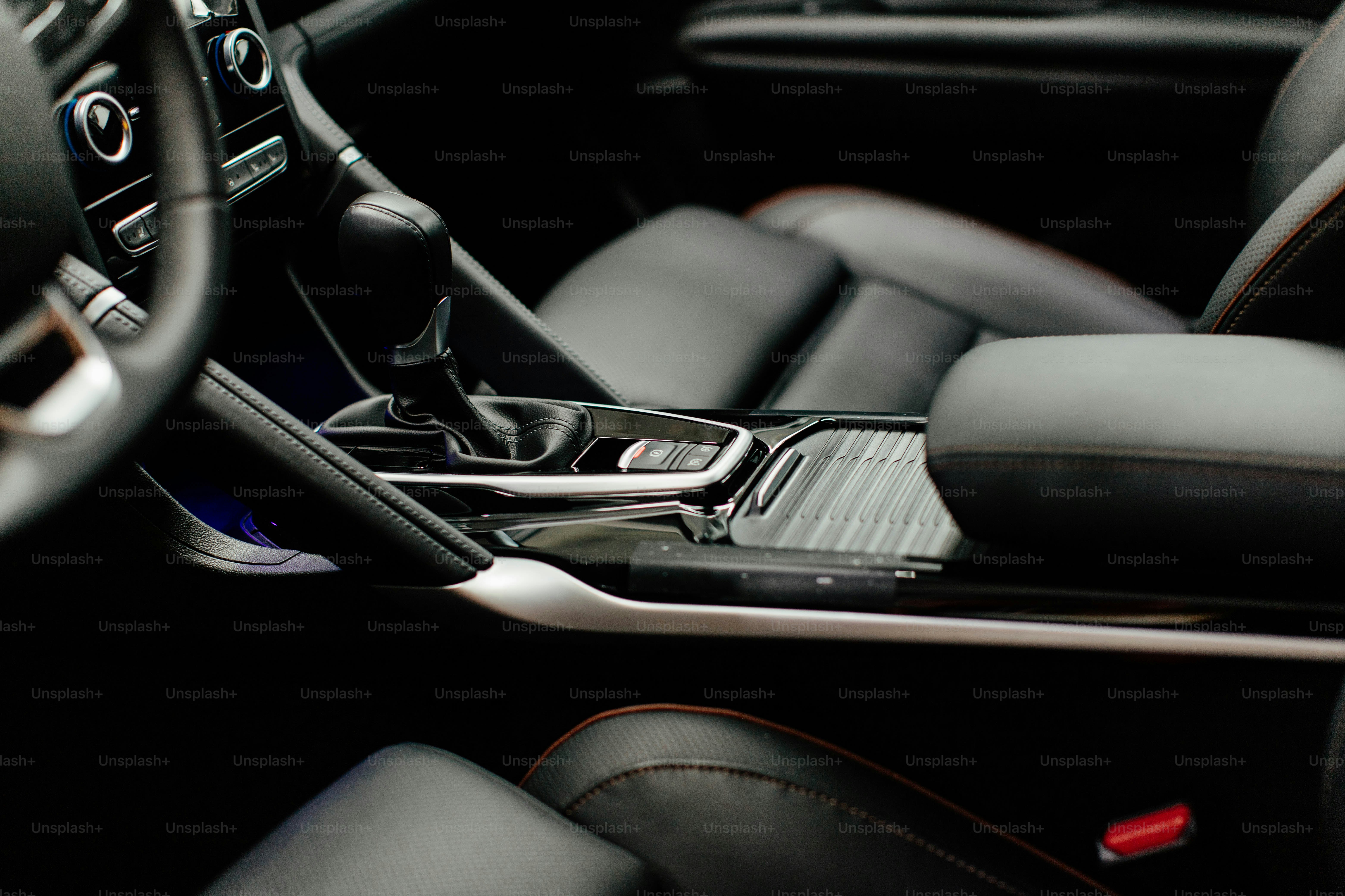 the interior of a car with a cell phone in the center console