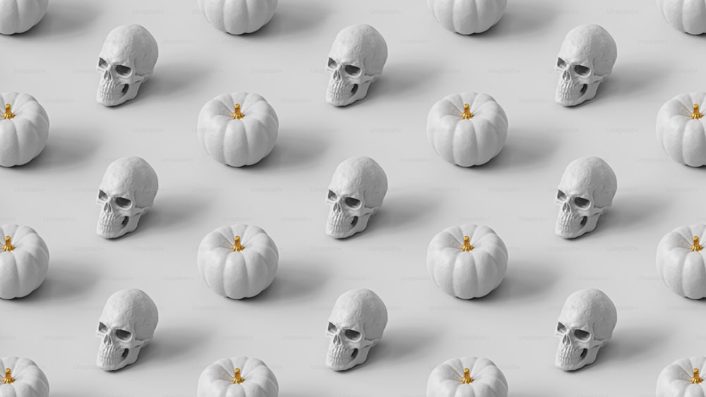 a group of skulls and pumpkins on a white surface