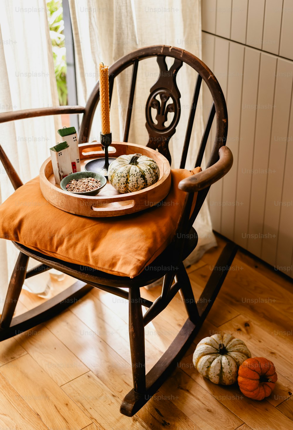 a wooden rocking chair with a tray of food on it