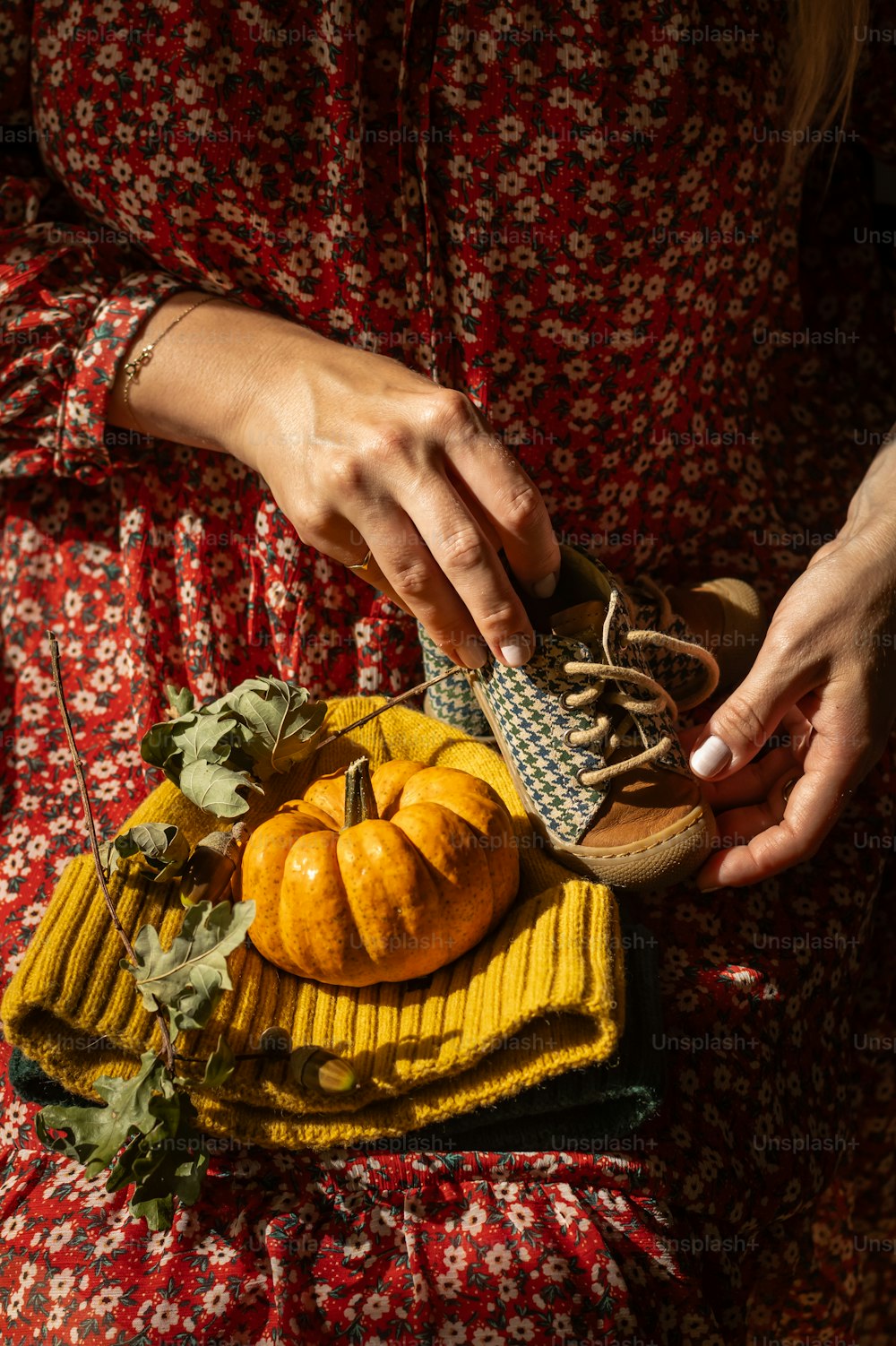 a woman is holding a basket of pumpkins