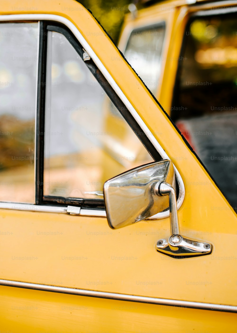 a close up of the side view mirror of a yellow car
