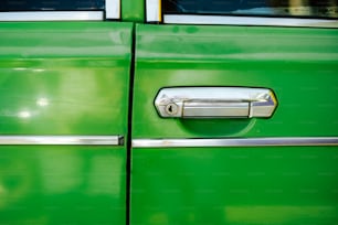 a close up of a door handle on a green car