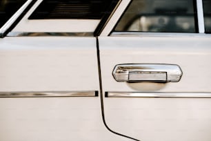 a close up of a door handle on a white car