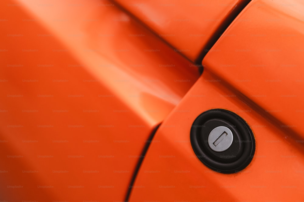 Un primer plano de la manija naranja de la puerta de un coche