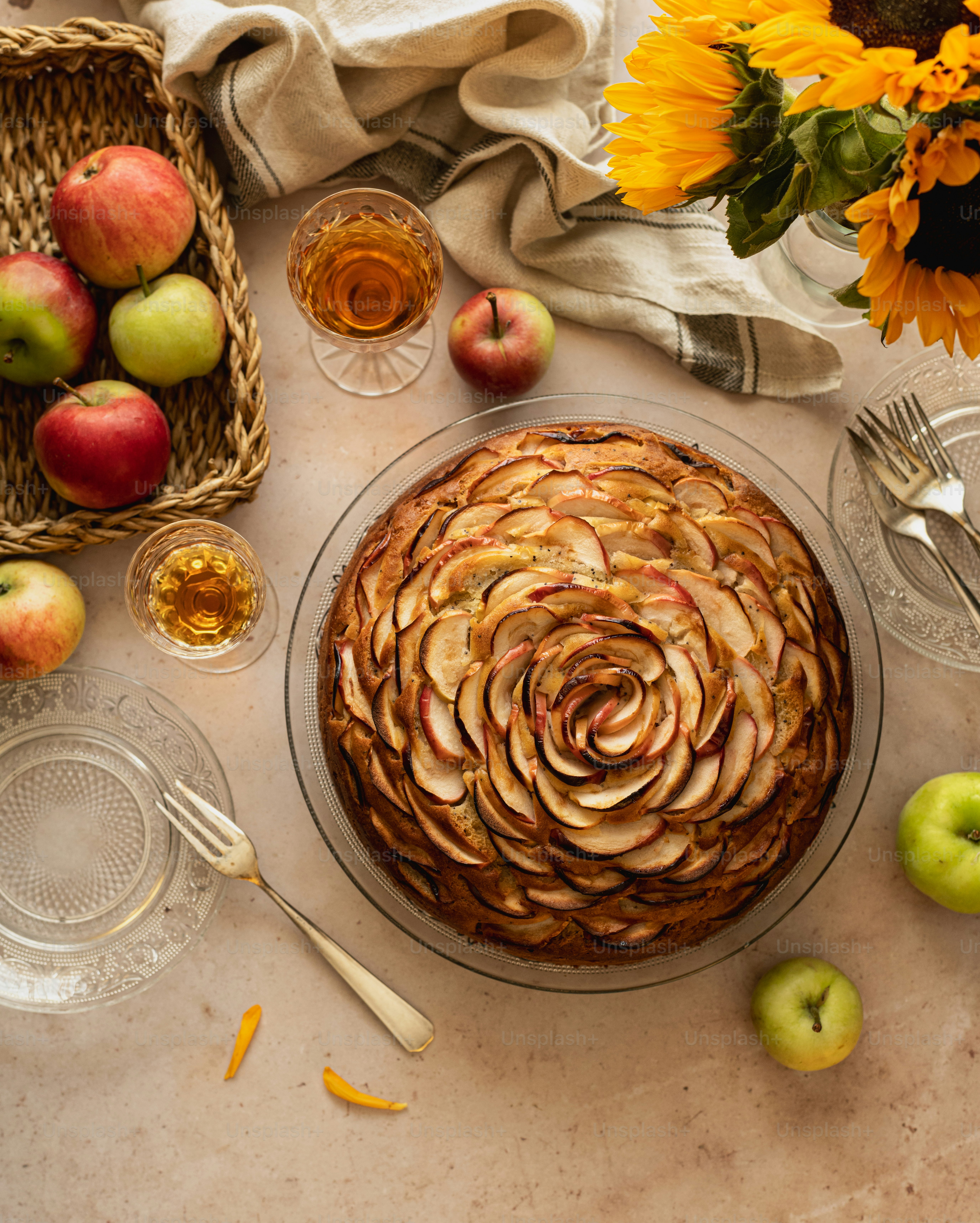 a table topped with a pie covered in apples