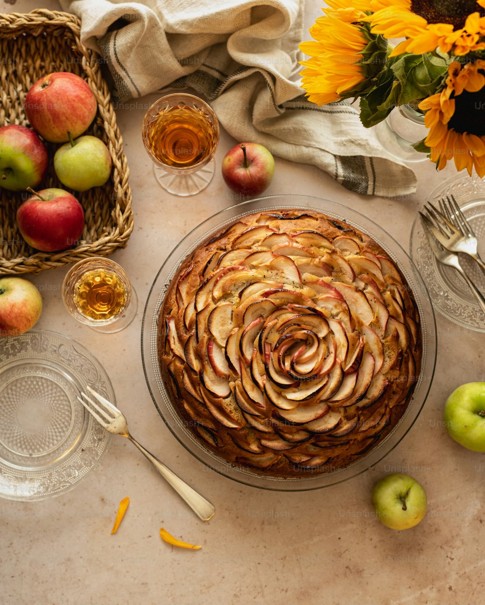 a table topped with a pie covered in apples