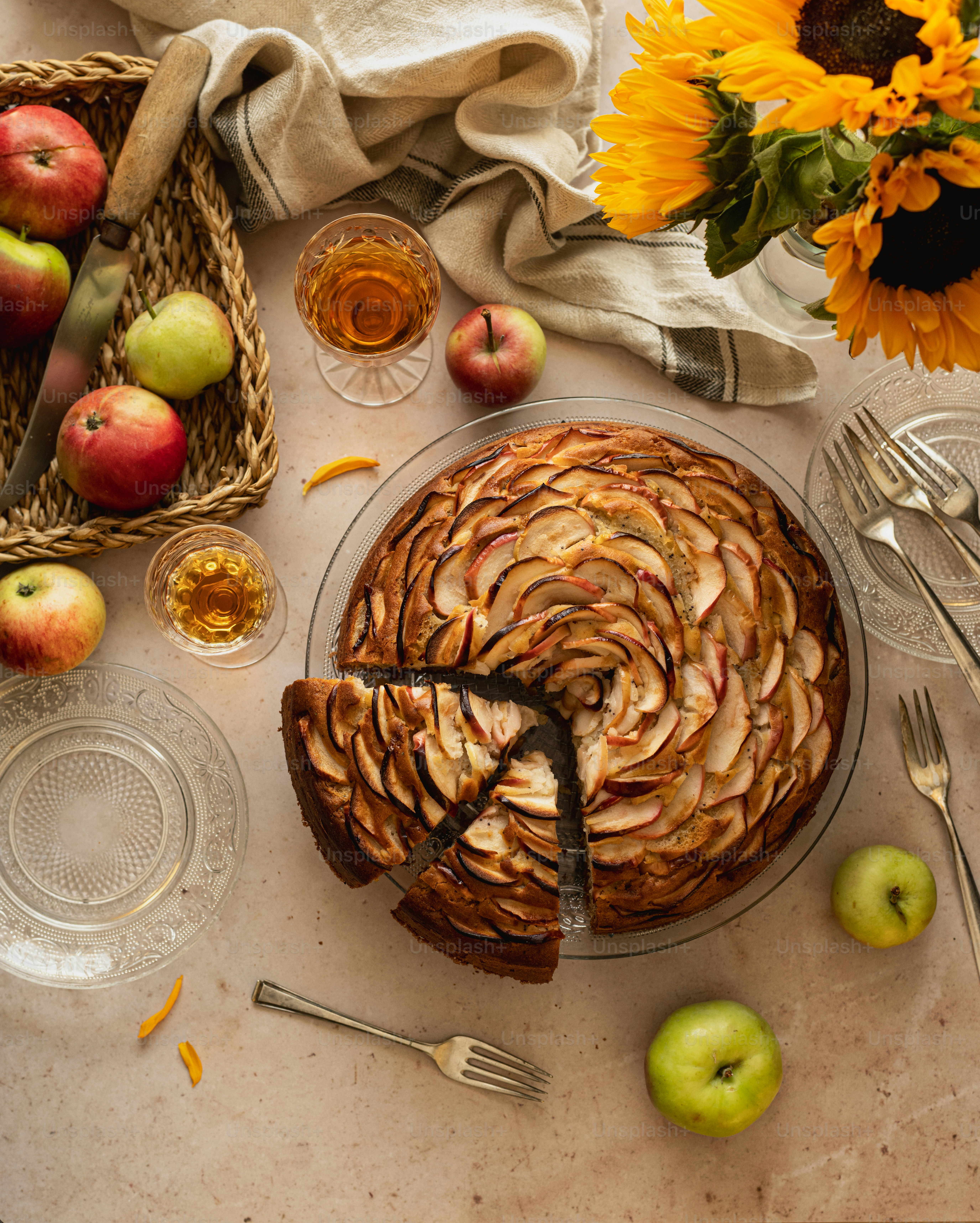 ein Tisch mit einem mit Äpfeln bedeckten Kuchen