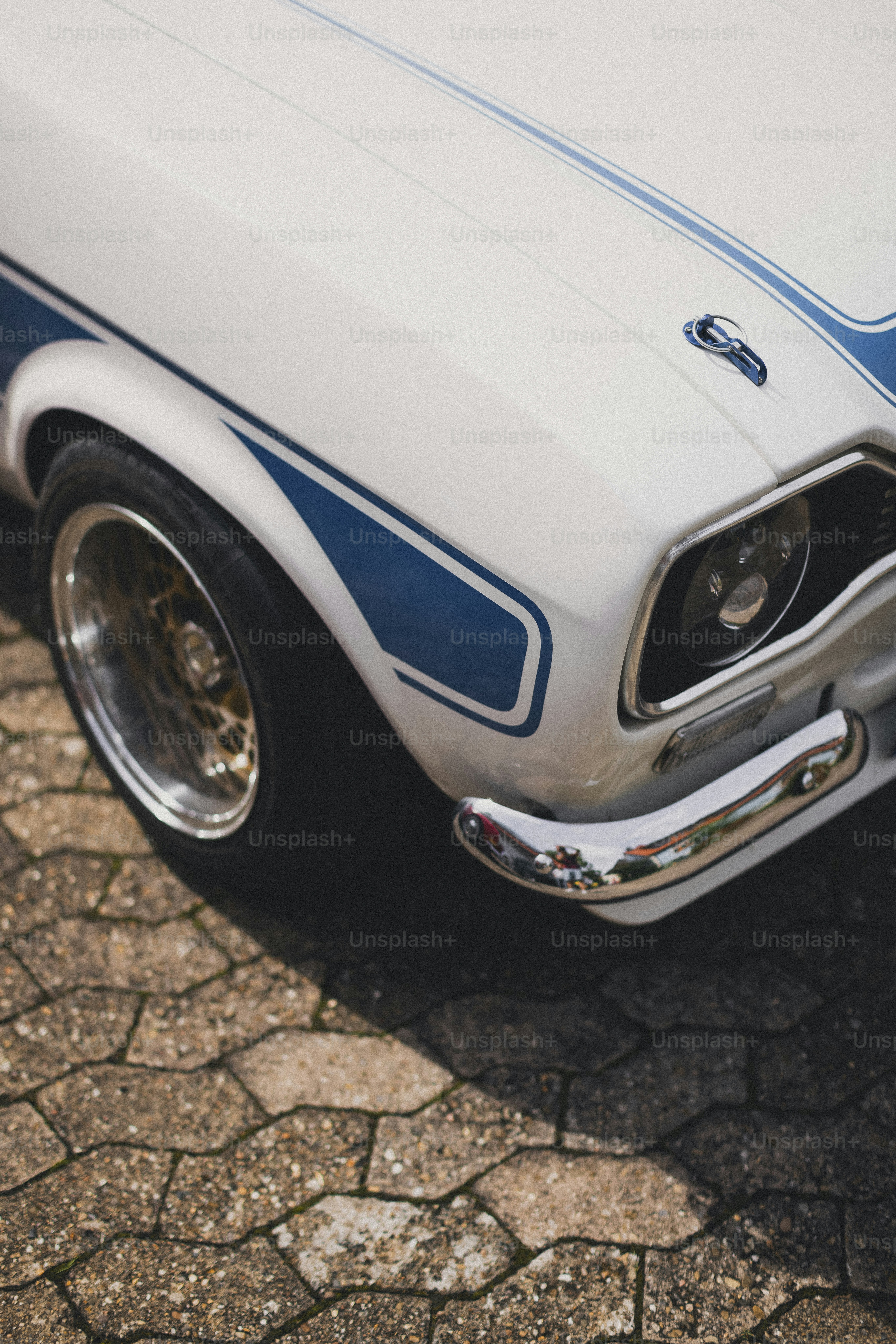 a white and blue car is parked on the street