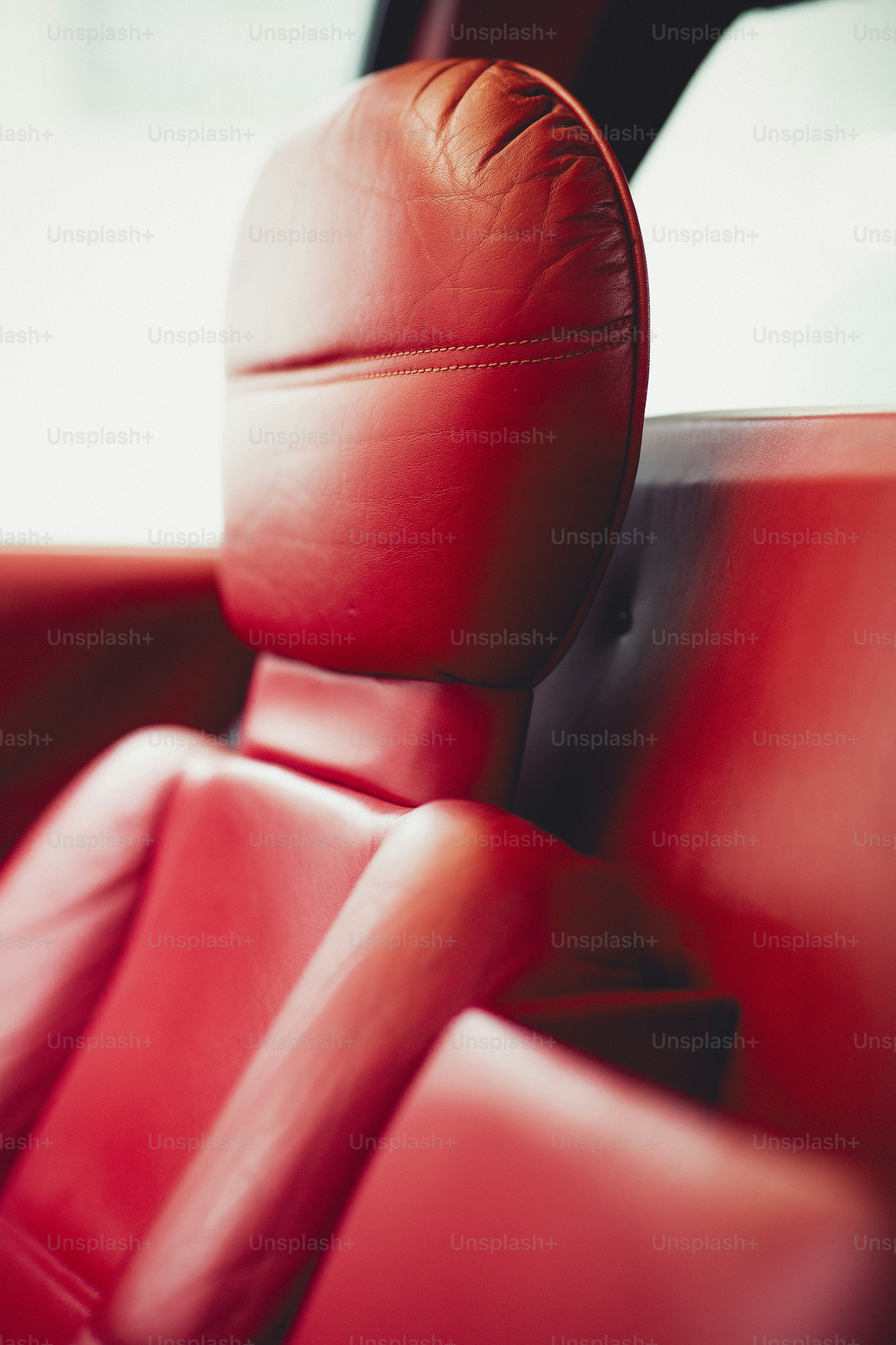 a red leather seat in a car with a steering wheel