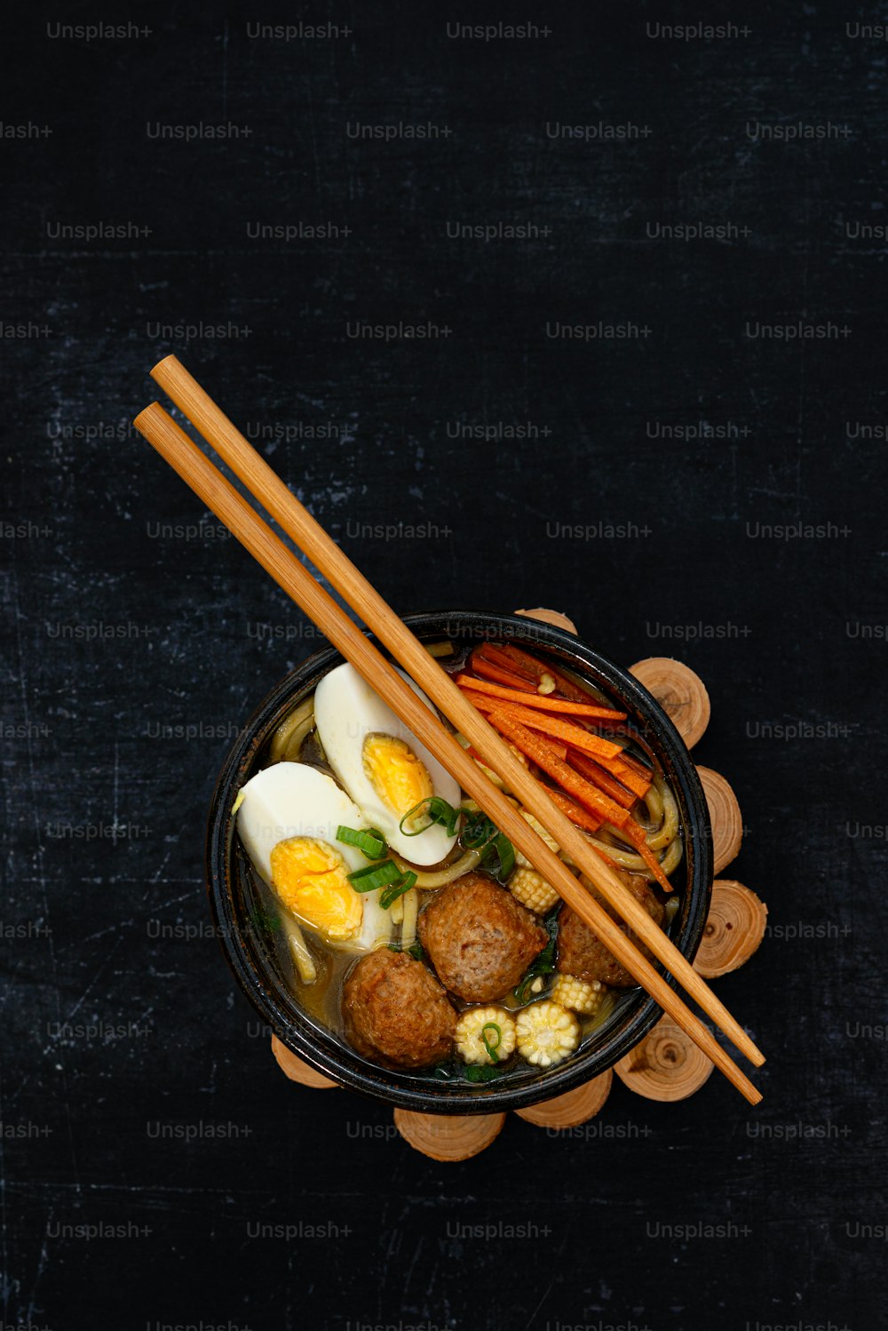 a bowl of food with chopsticks and eggs