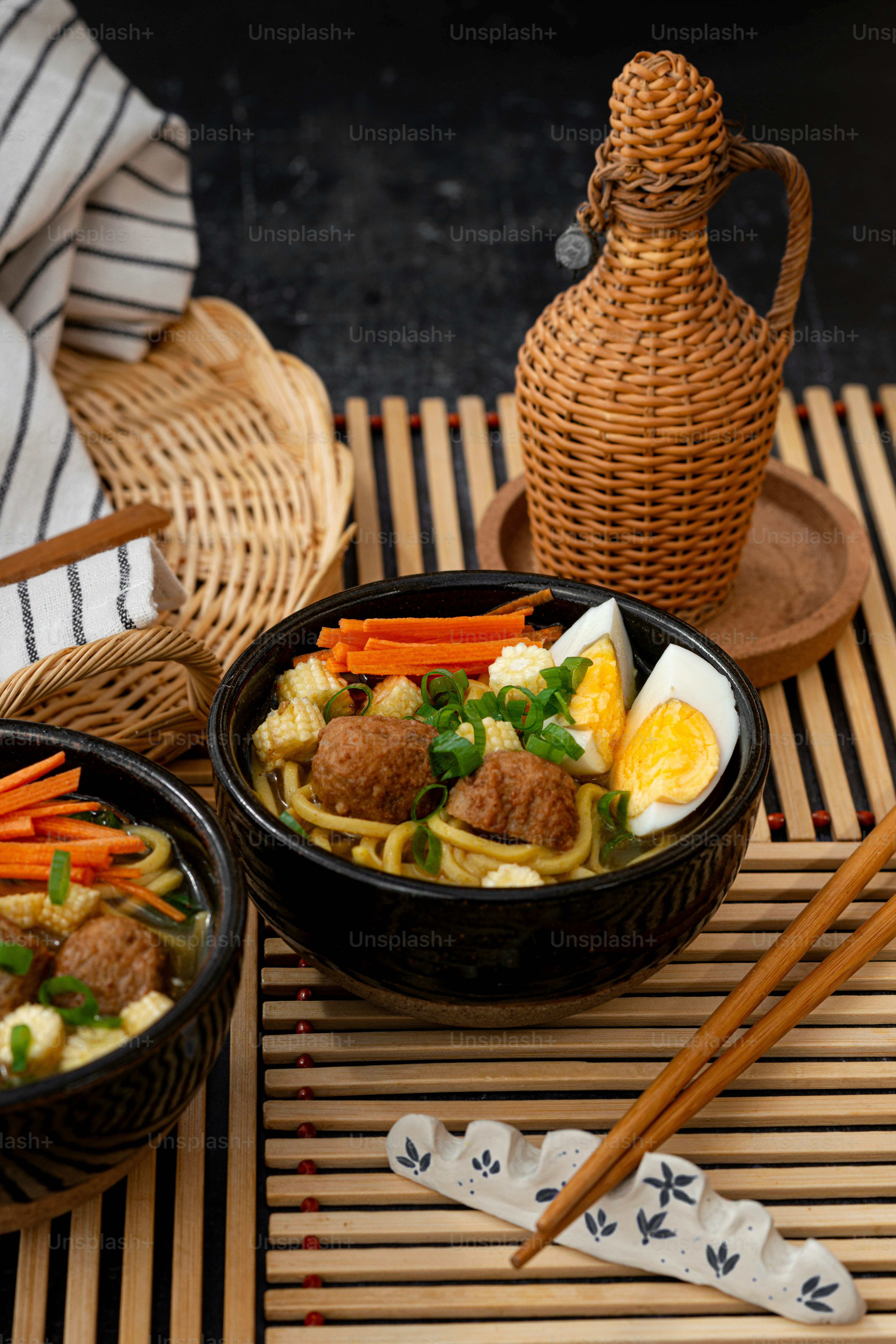 Dos tazones de comida en una estera con palillos