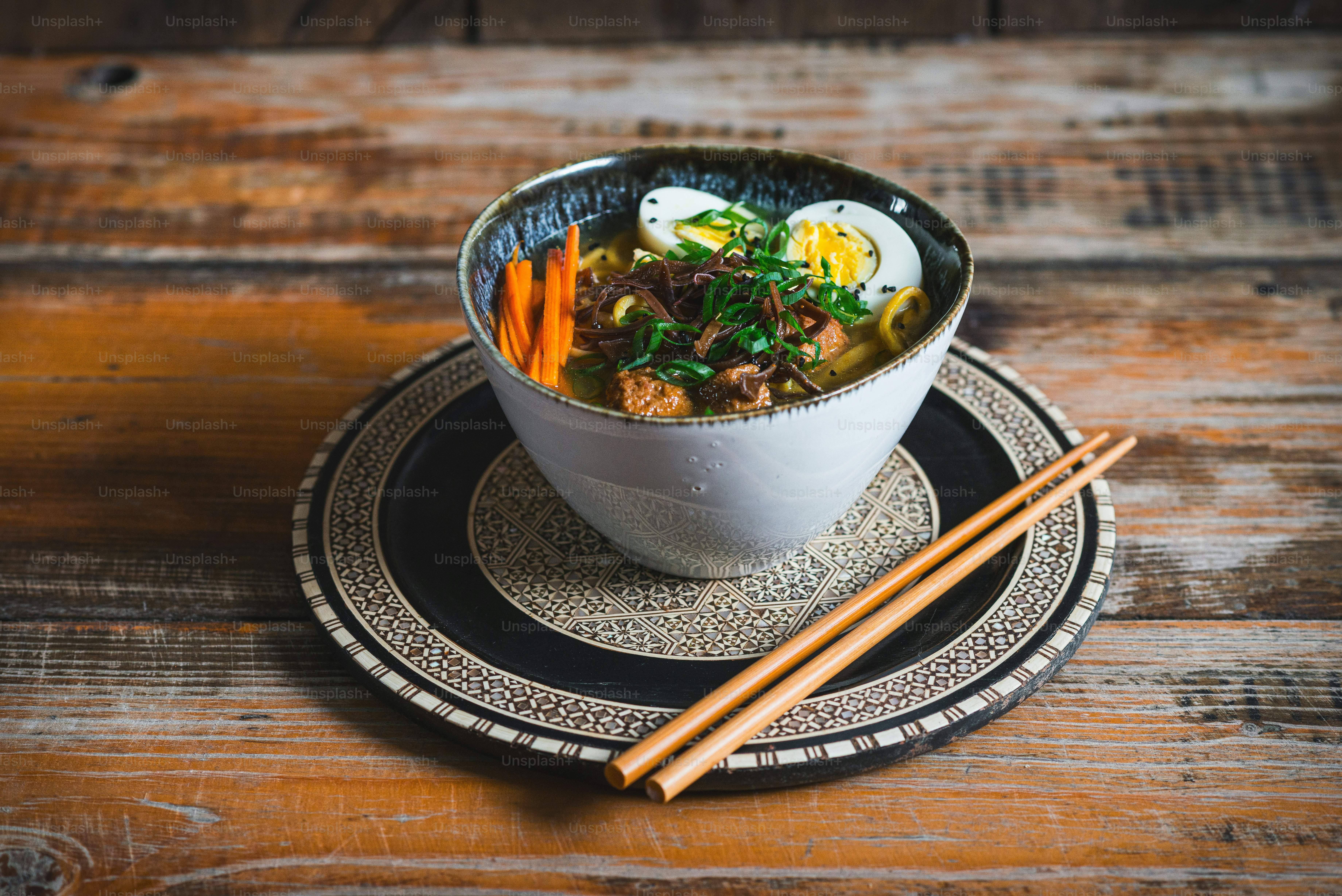 un plato de sopa en un plato con palillos
