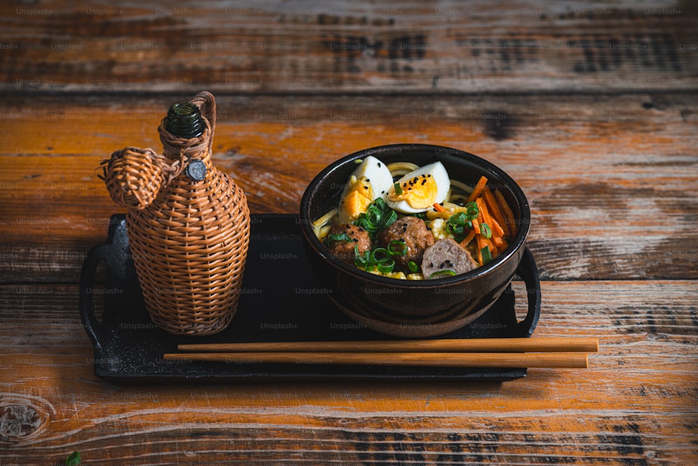 a bowl of food and chopsticks on a tray