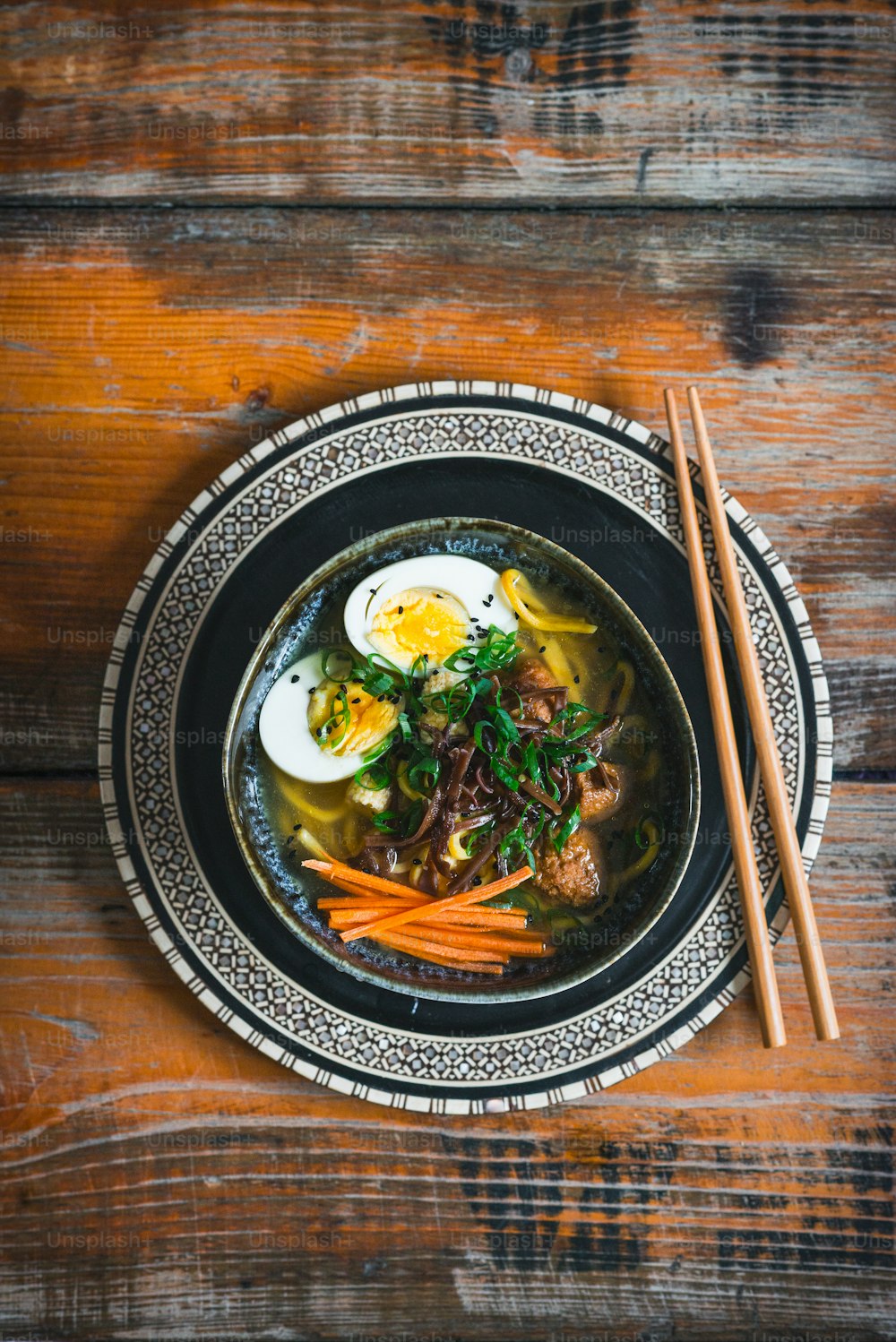 a bowl of soup with meat, carrots and an egg