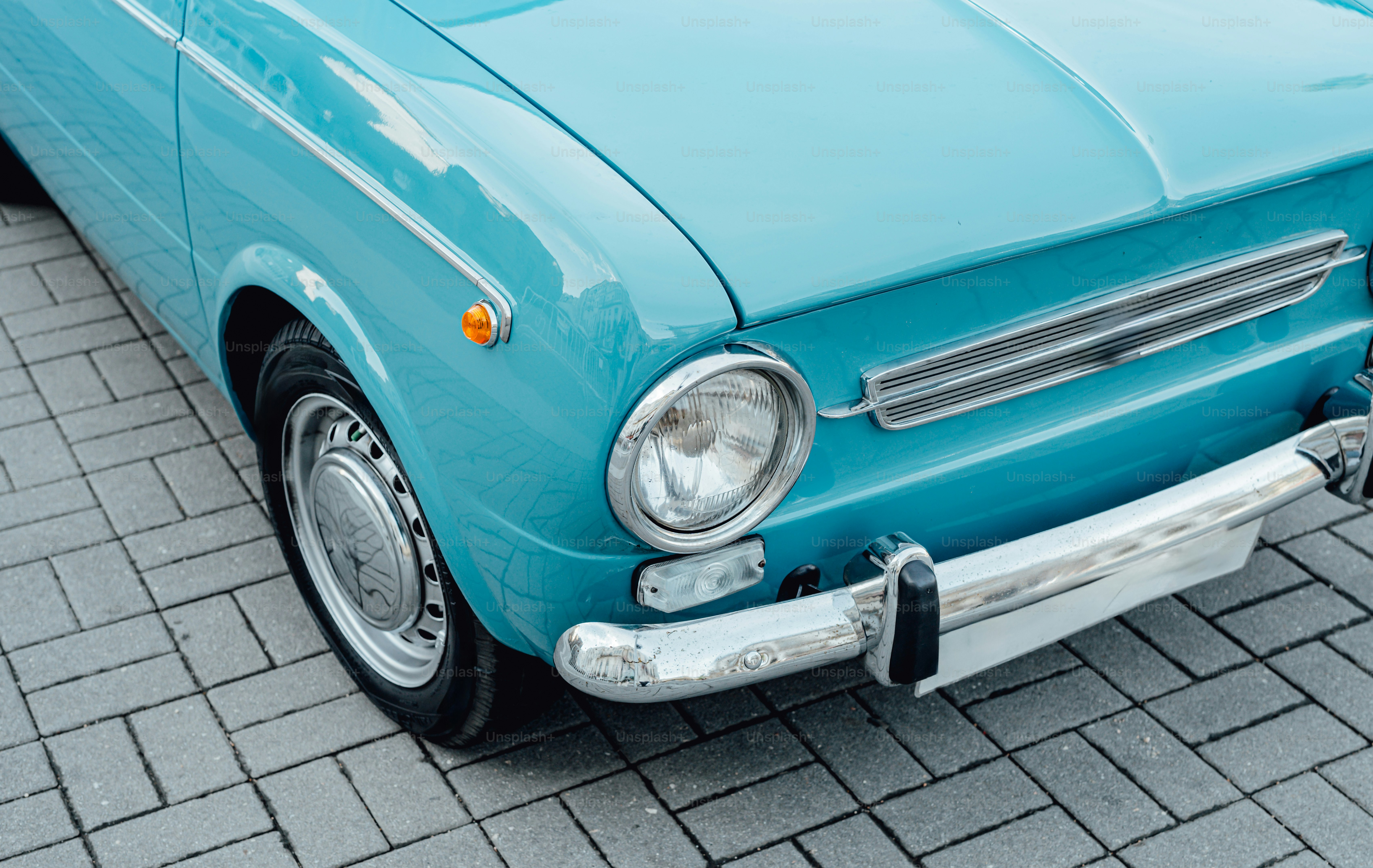 Une voiture bleue garée sur une route en briques