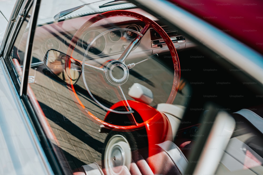 a car with a steering wheel and a red seat