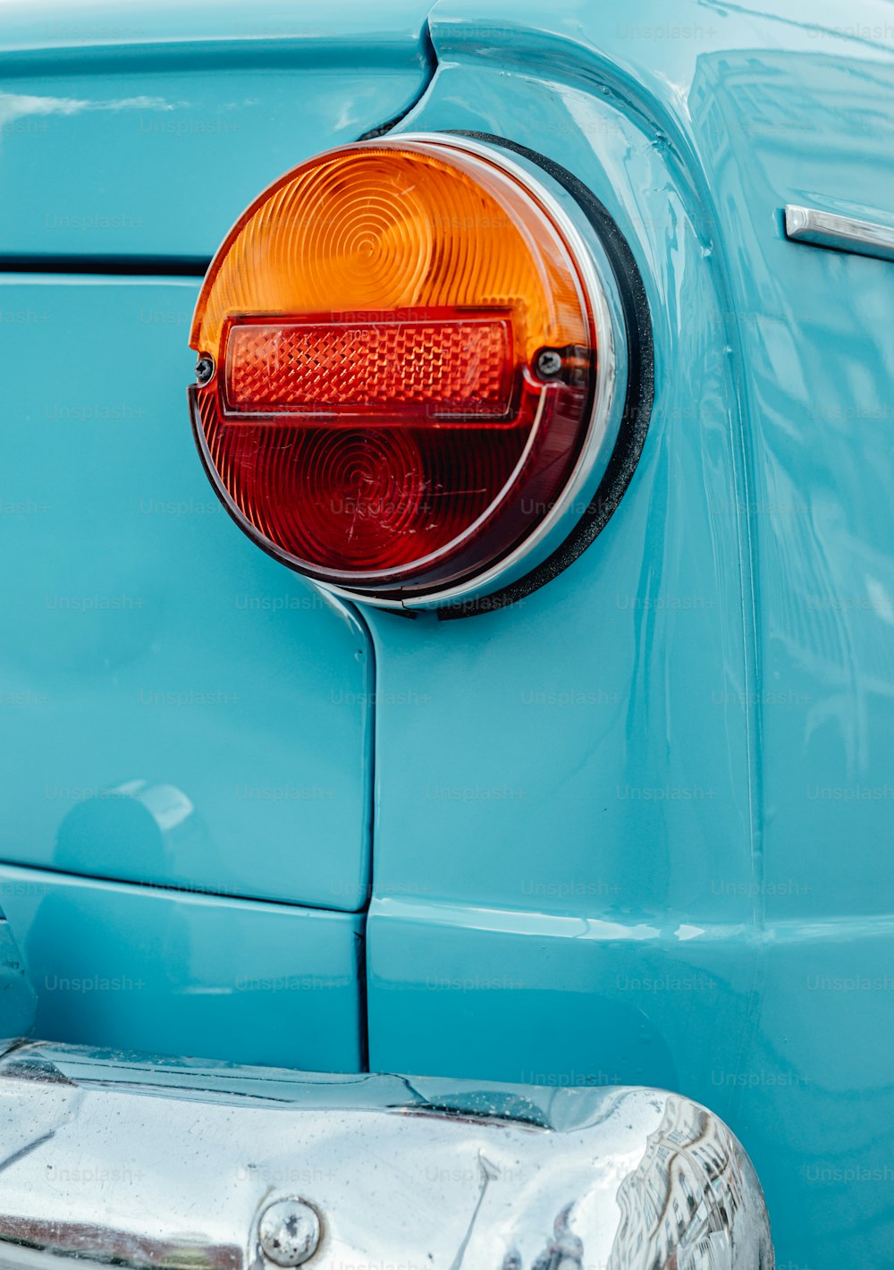 a close up of the tail light of a blue car