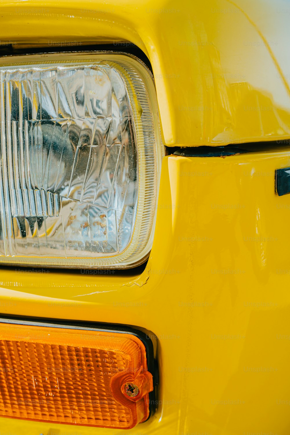 a close up of the front end of a yellow car