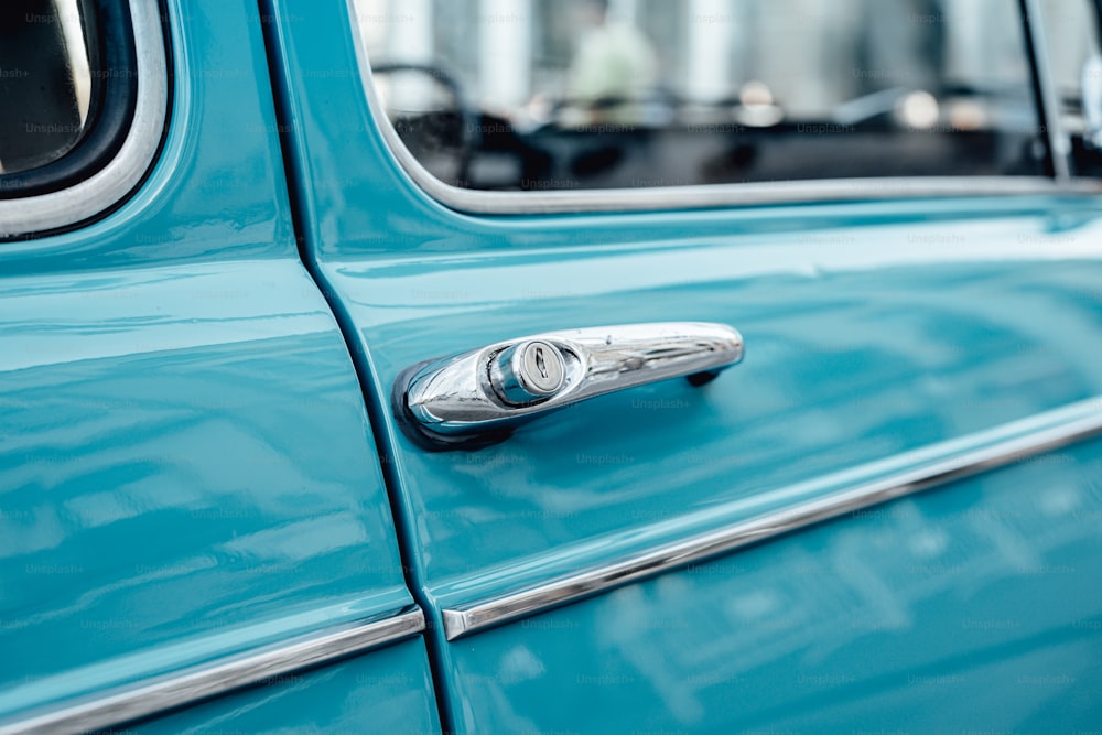 a close up of a door handle on a blue car
