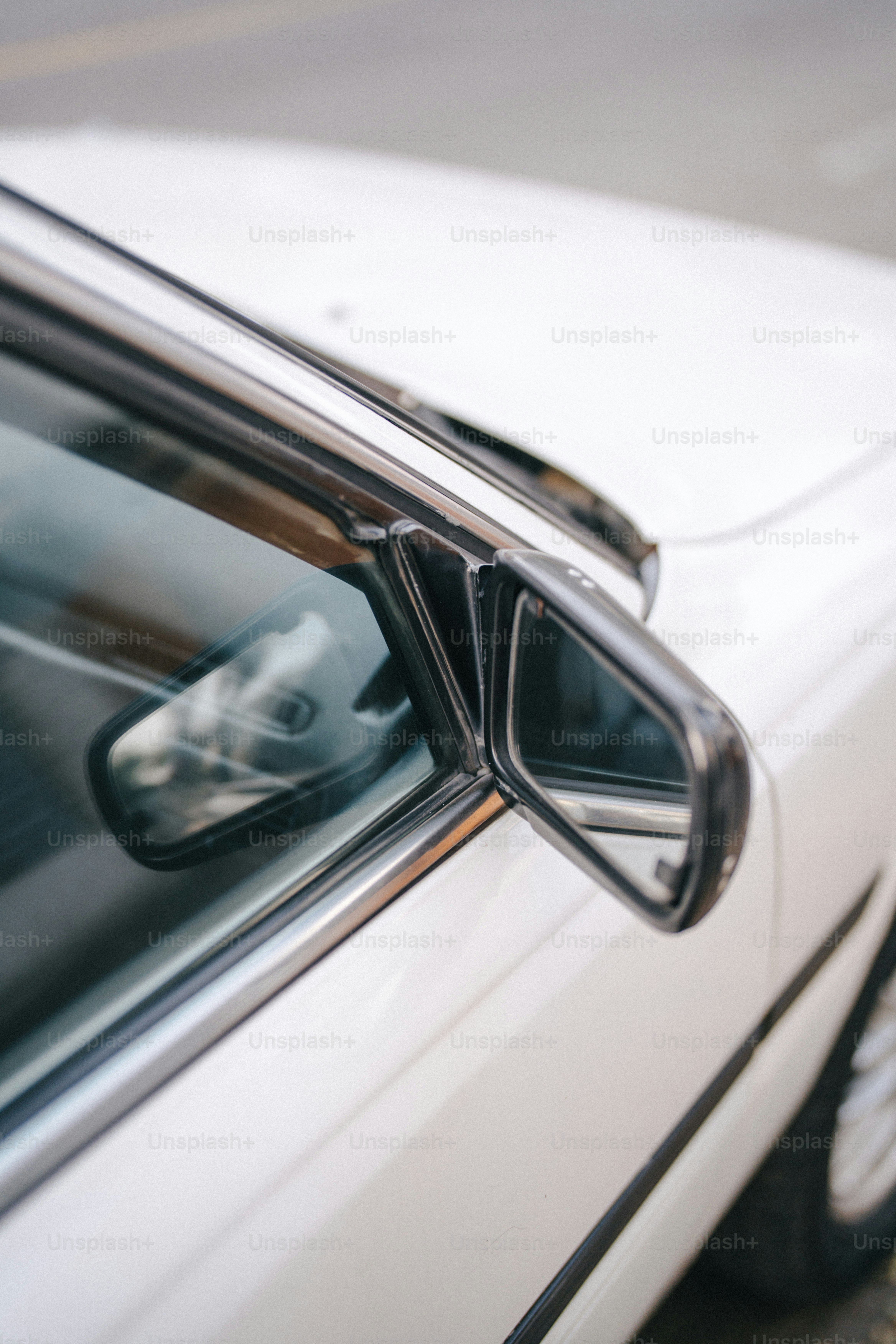 Un coche blanco con un perro asomando la cabeza por la ventanilla