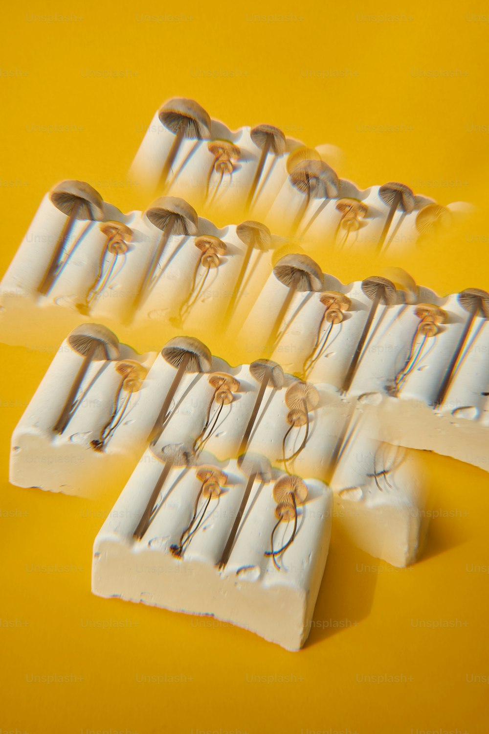Un primo piano di un gruppo di spazzolini da denti su uno sfondo giallo