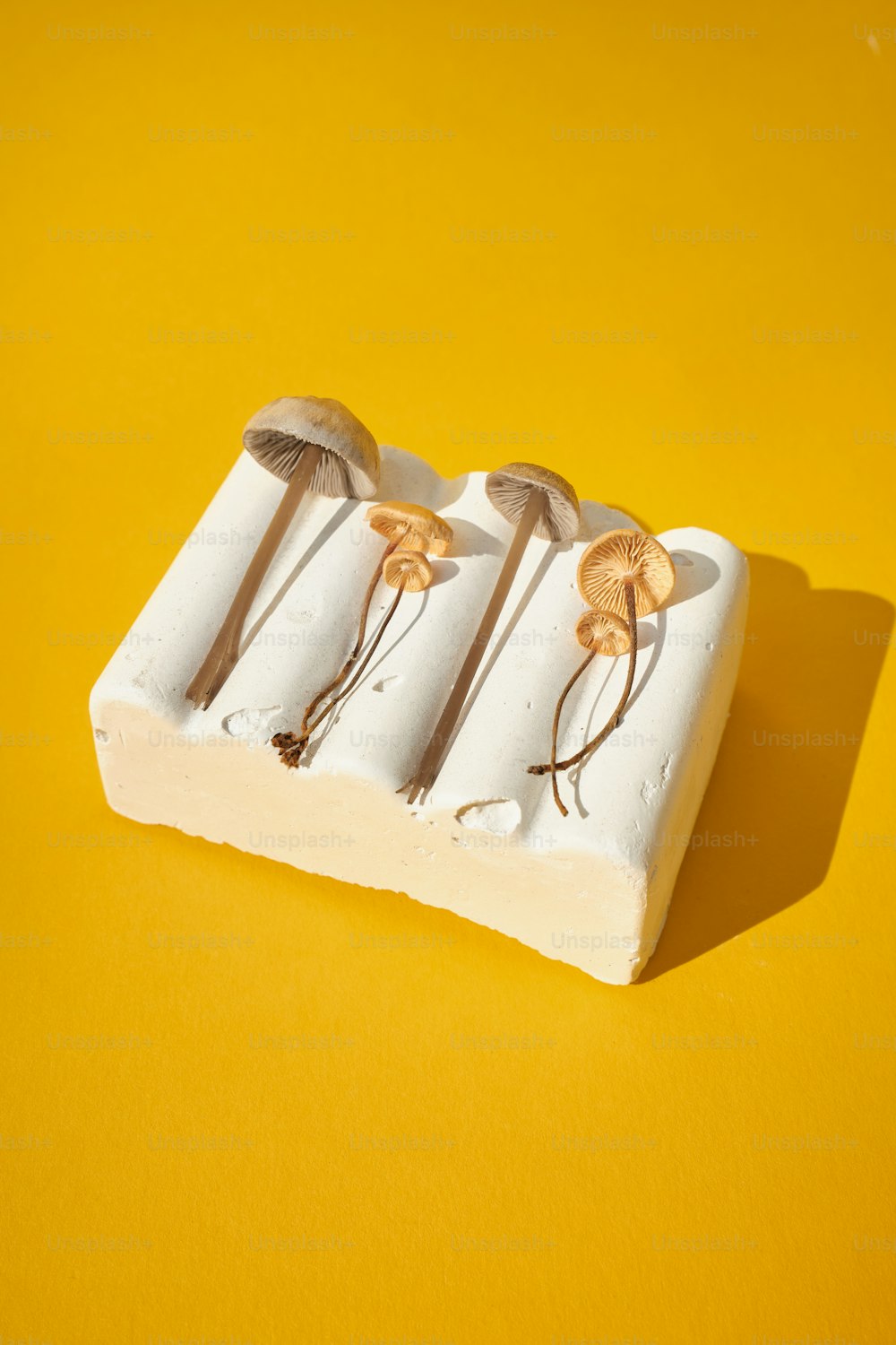 three small pieces of food with spoons on a yellow surface