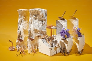 Un grupo de esculturas con flores sobre un fondo amarillo