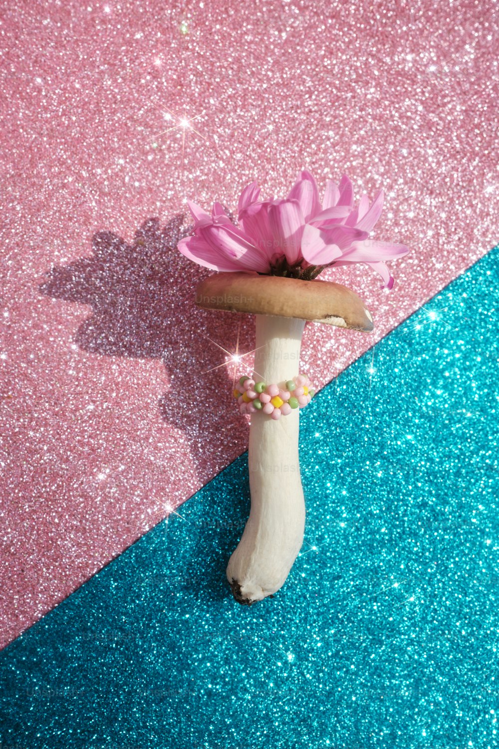 a pink flower sitting on top of a white bone