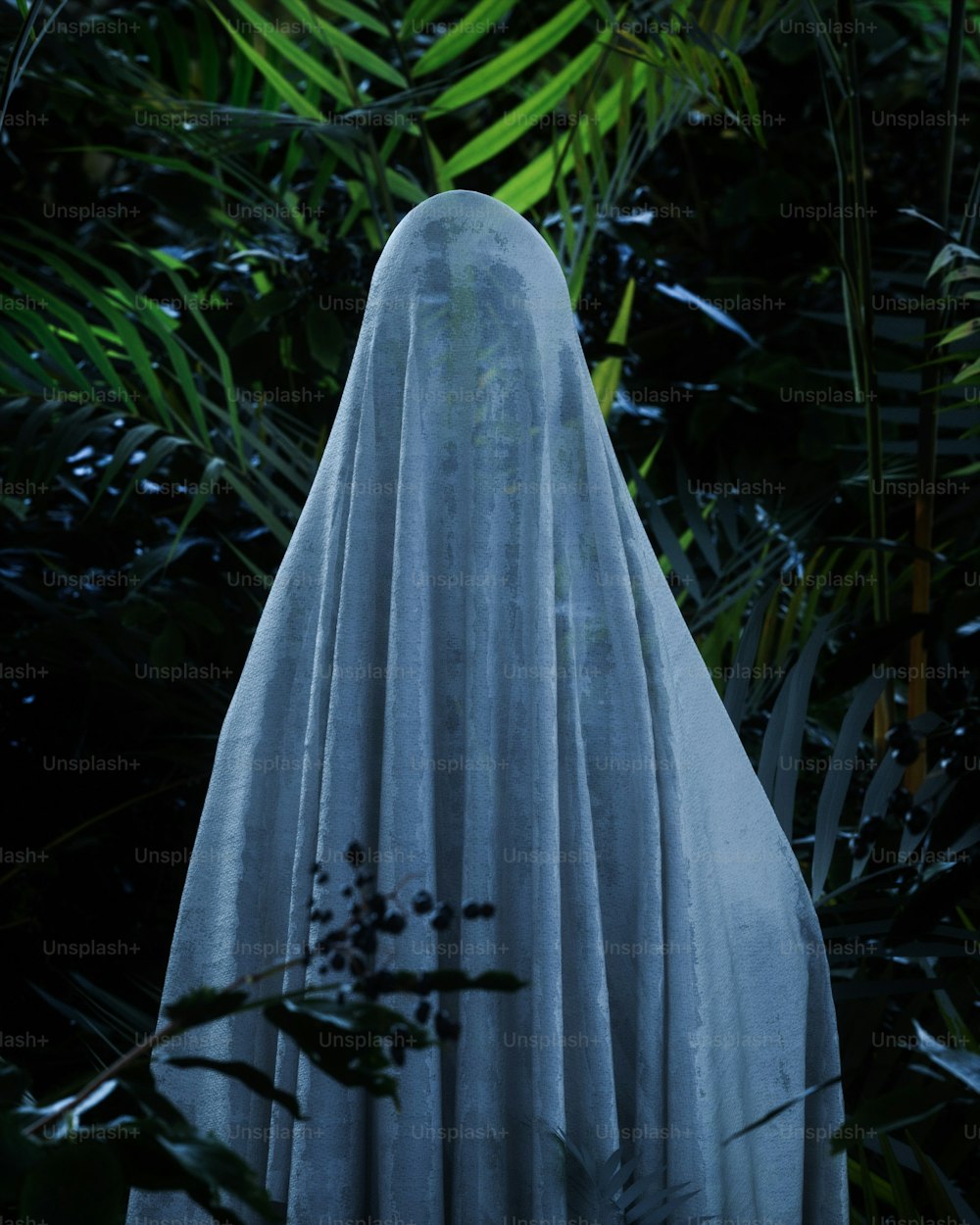 uma estátua de um fantasma no meio de uma floresta