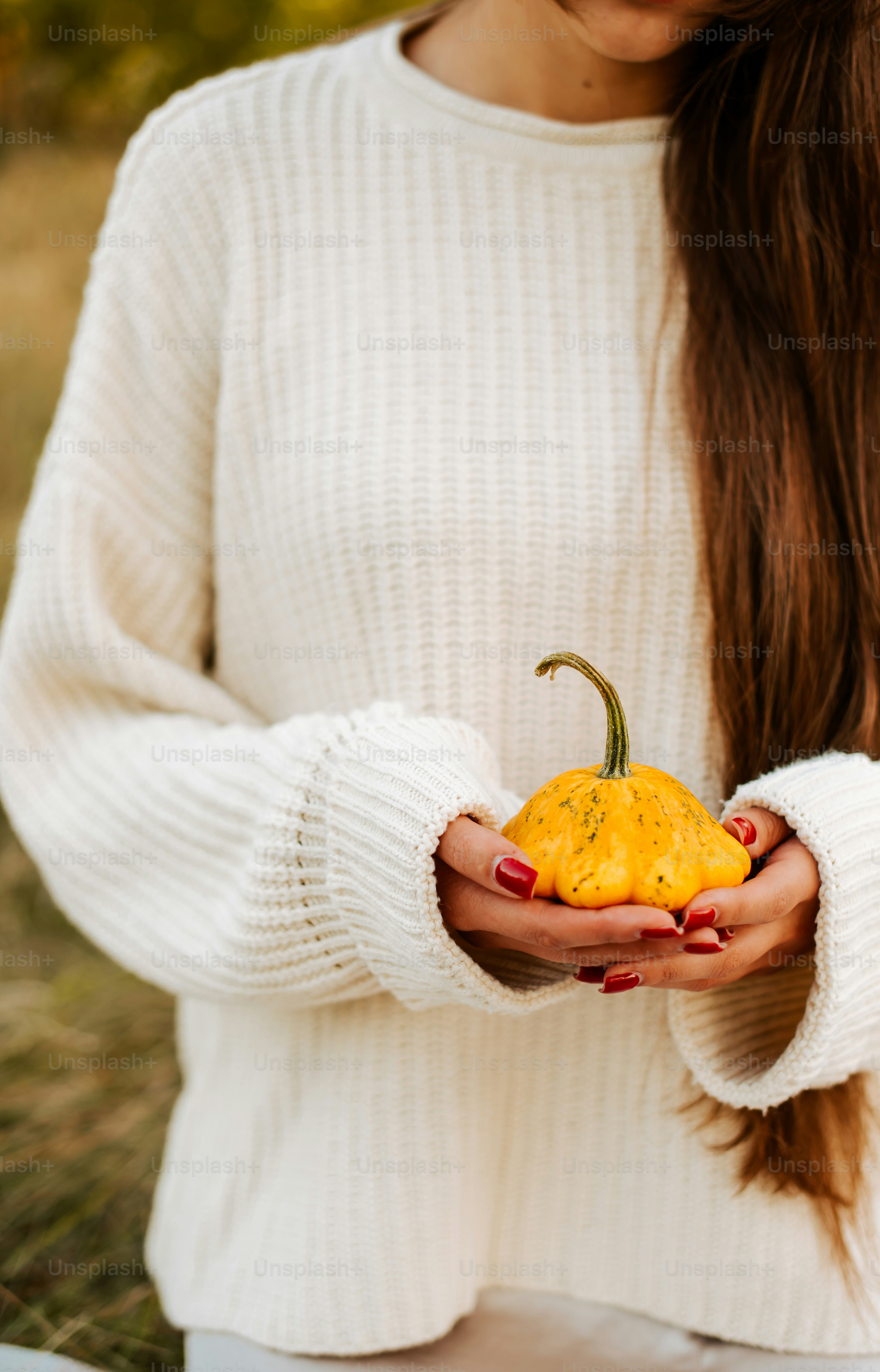 a woman holding a yellow pepper in her hands