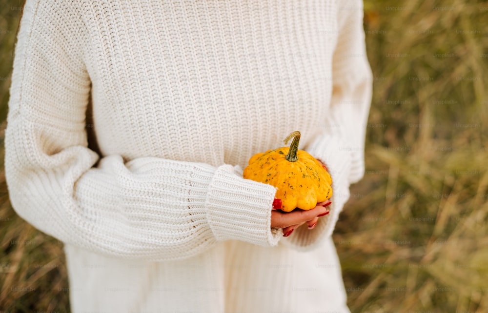 a woman holding a pumpkin in her hands