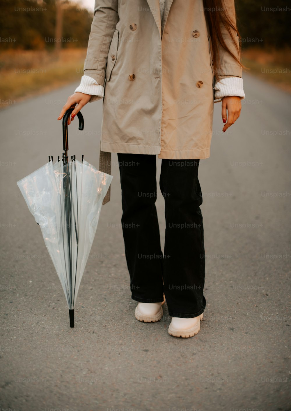 a woman in a trench coat holding an umbrella