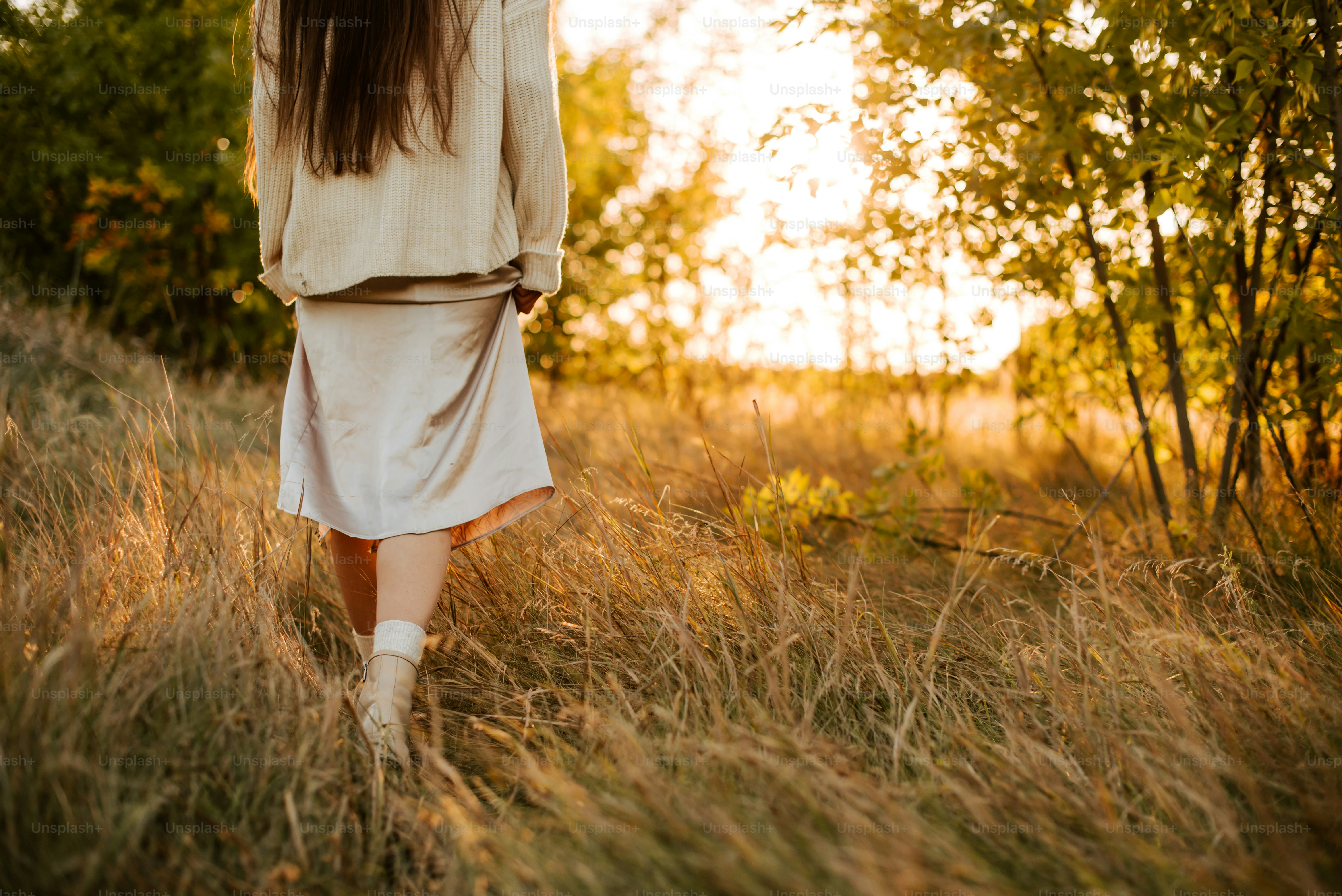 A woman walking through a field of tall grass photo – Lifestyle Image ...