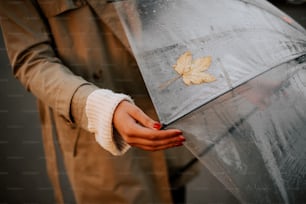 a woman holding an umbrella with a leaf on it