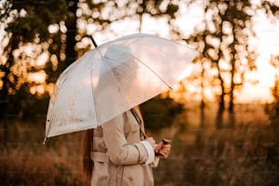 傘をさして野原に立つ女性