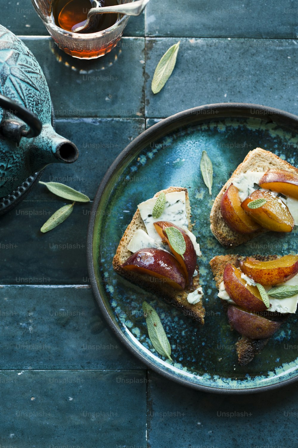 a plate of food on a table next to a teapot