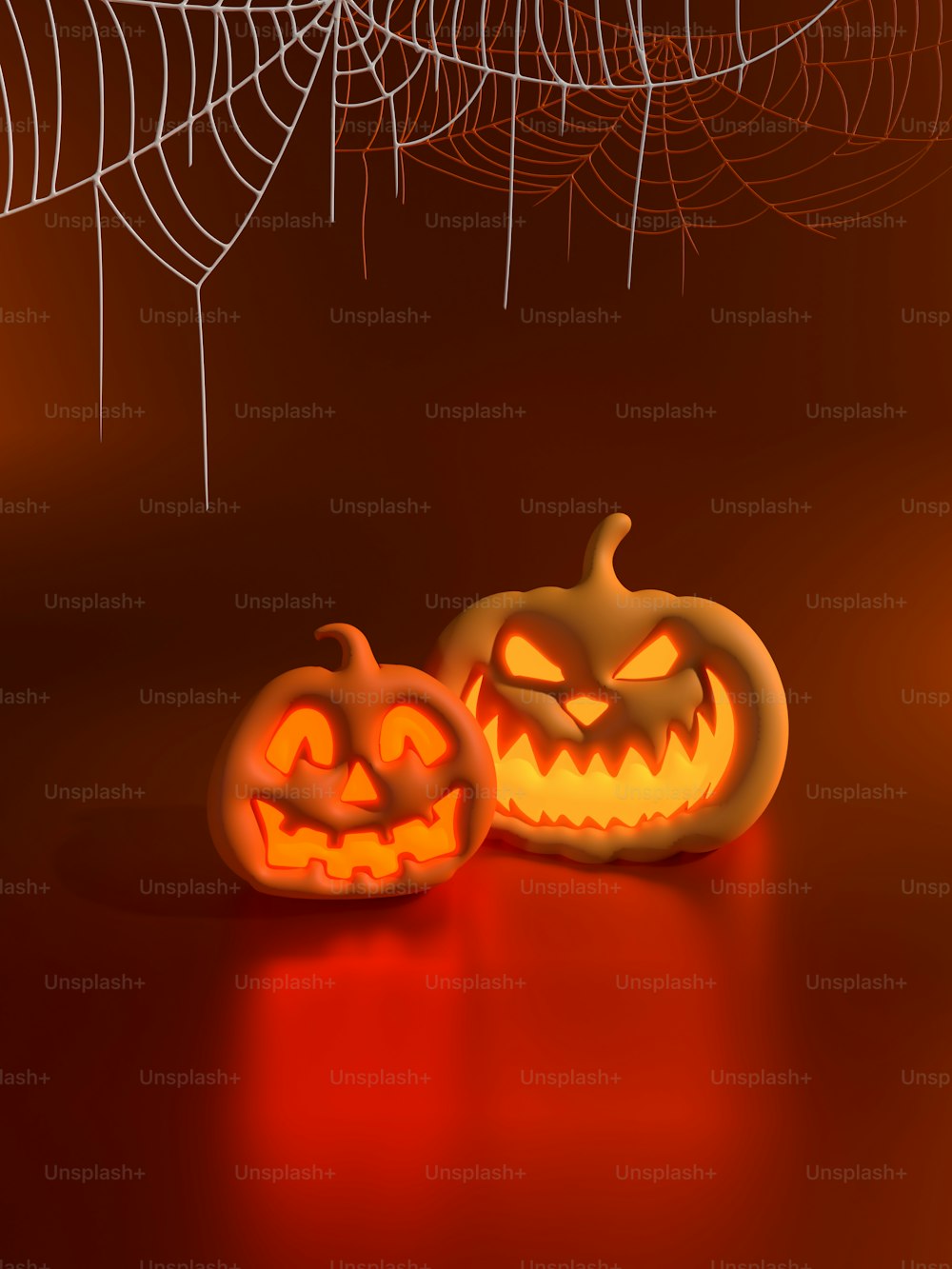 two carved pumpkins on a table with a spider web in the background