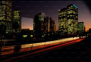 a city skyline at night with lights streaking by