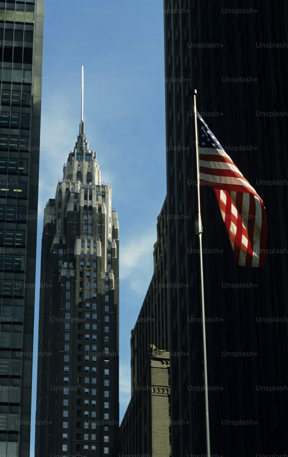 an american flag flying in front of a tall building