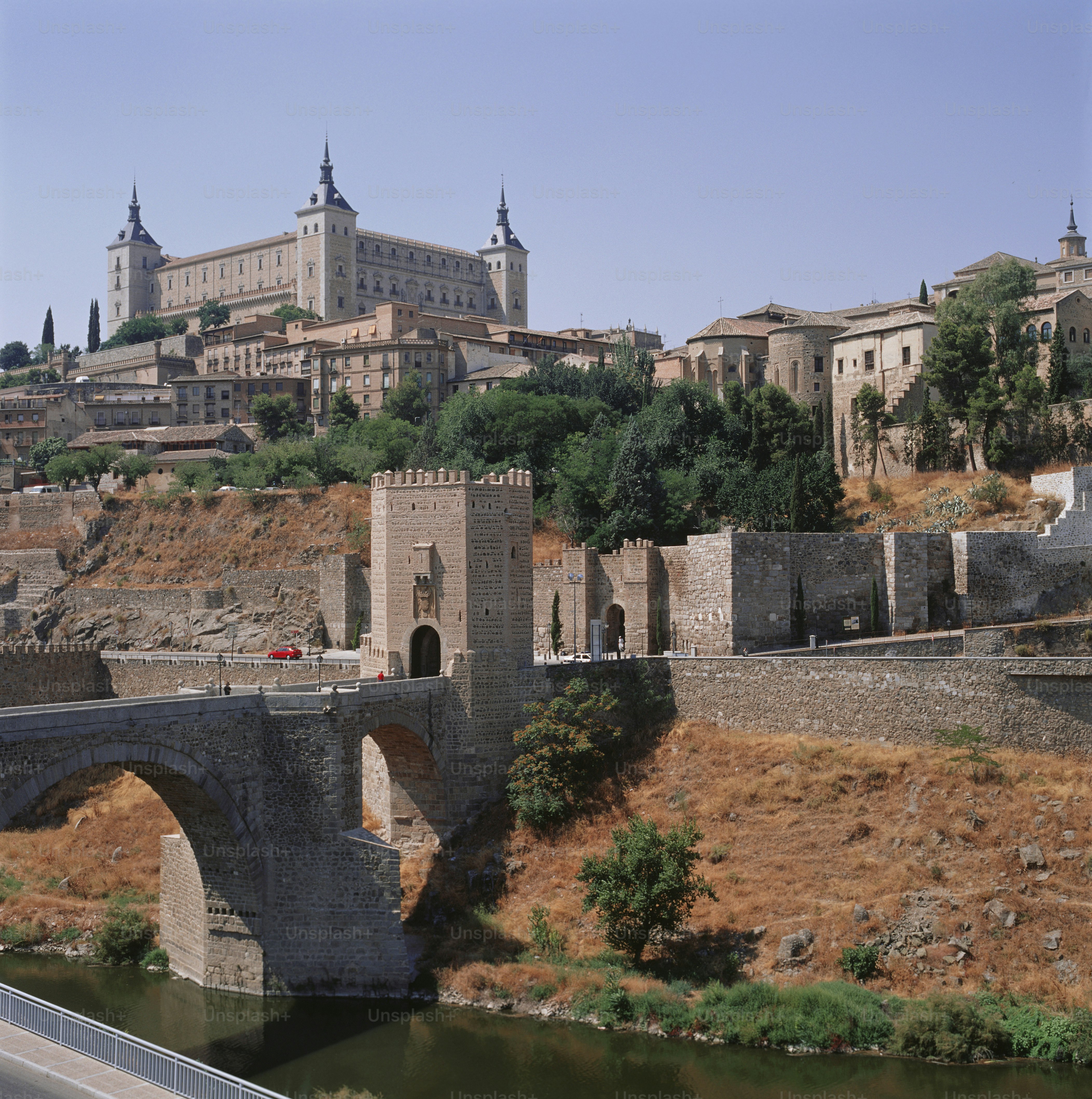 a bridge over a river with a castle in the background